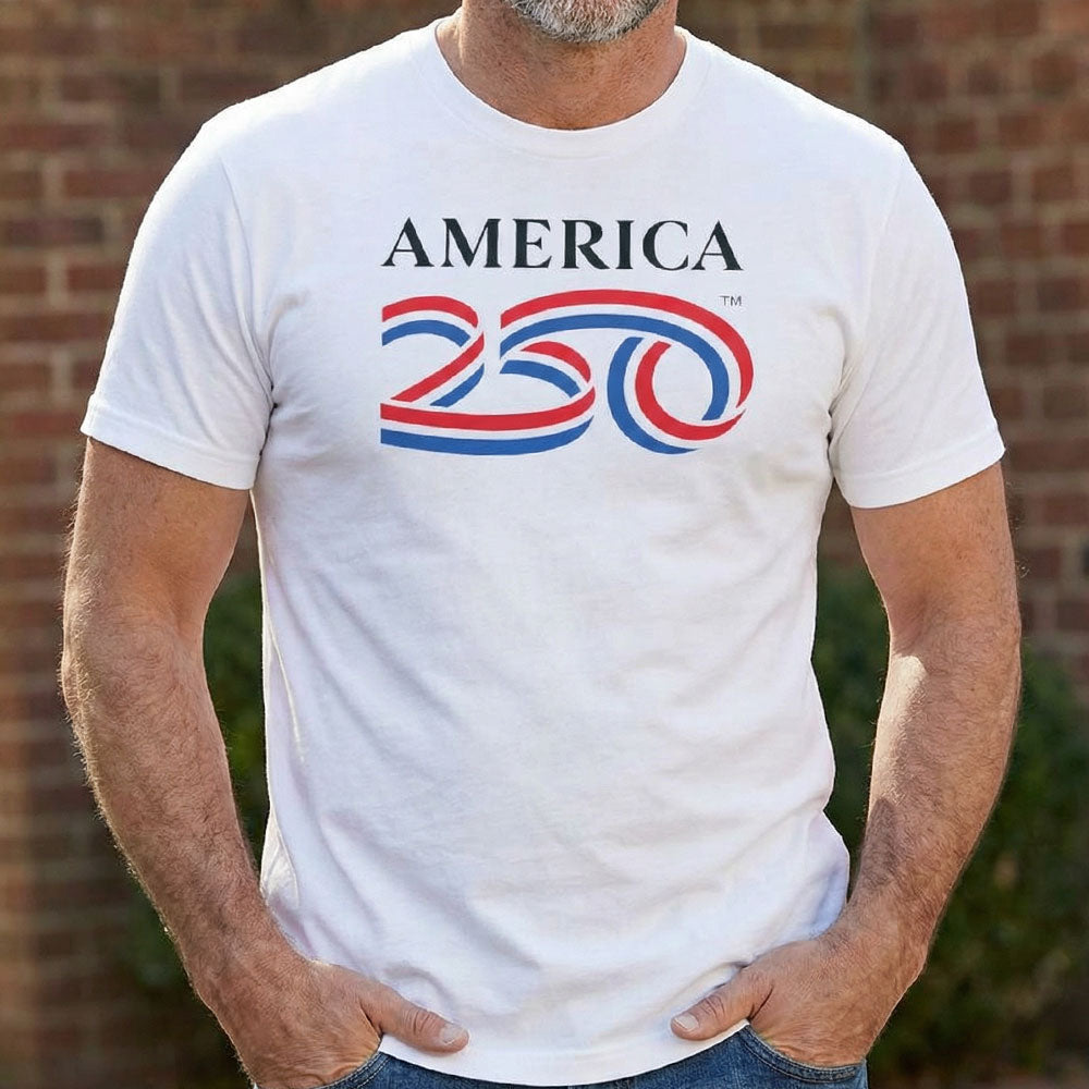 Person wearing a white t-shirt with 'AMERICA 200' design against a brick wall.